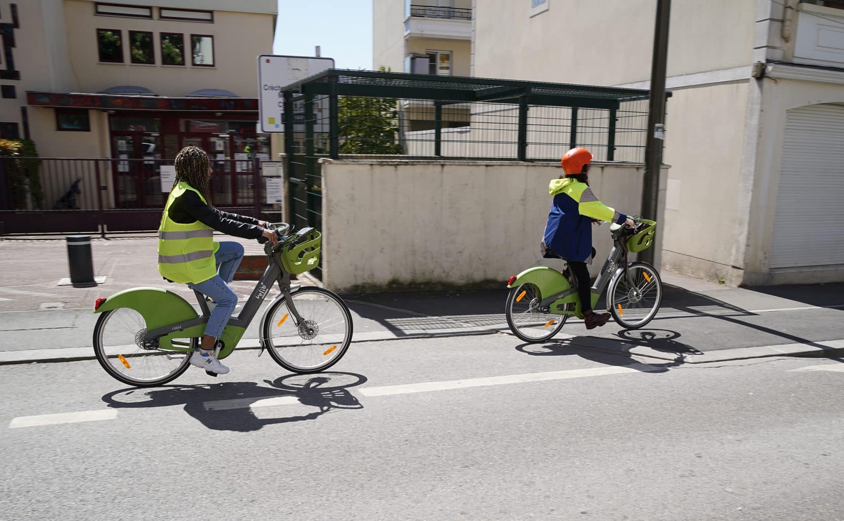 Cyclistes en ville, avec casque et gilets/blouson réfléchissants.